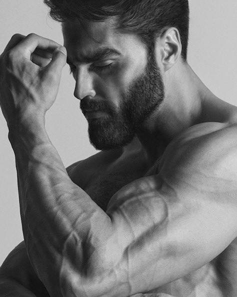 Muscular man flexing his bicep in black and white.