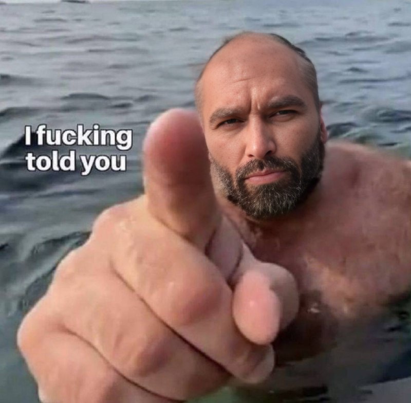 Muscular man pointing from water with serious expression.