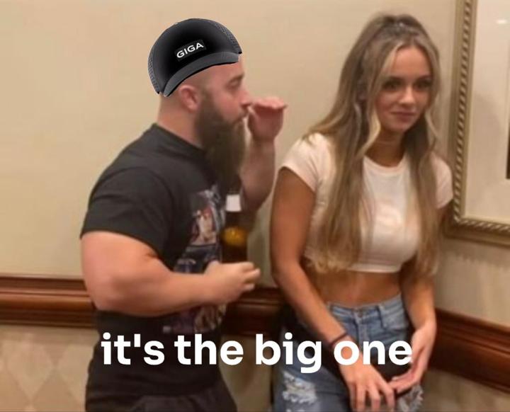 A man in a GIGA hat whispers to a woman.